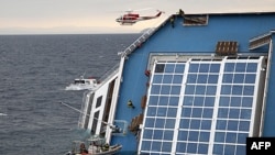 Nhân viên cứu nạn leo lên tàu Costa Concordia, bị lật nằm nghiêng một bên