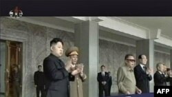 Lãnh tụ Bắc Triều Tiên Kim Jong Il (đeo kính đen, giữa) và người con trai Kim Jong-un (trái) xem diễu binh tại quảng trường chính ở Bình Nhưỡng, 9/9/2011