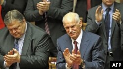 Thủ tướng Hy Lạp George Papandreou (phải) và Bộ trưởng Tài chánh Evangelos Venizelos vỗ tay sau khi giành chiến thắng trong cuộu biểu quyết tín nhiệm tại Quốc hội Hy Lạp, ngày 5 tháng 11, 2011