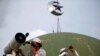 A boarding school student and an official wearing protective masks use a telescope and a monocular to view the moon on the roof of Al Musariin mosque to mark the first day of Ramadan, as the spread of the coronavirus disease (COVID-19) continues, in Jakar